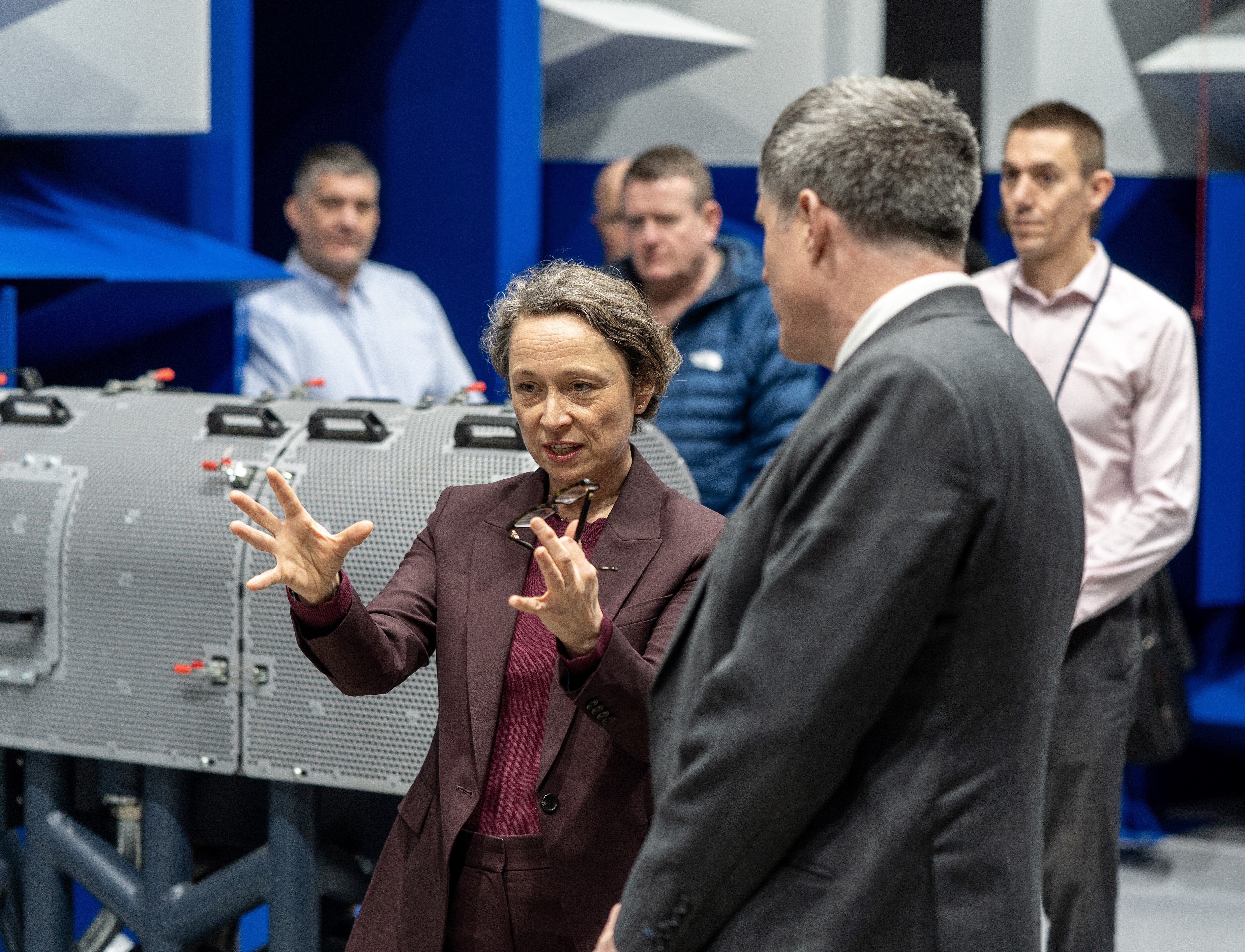 A woman explaining something in detail on a factory floor